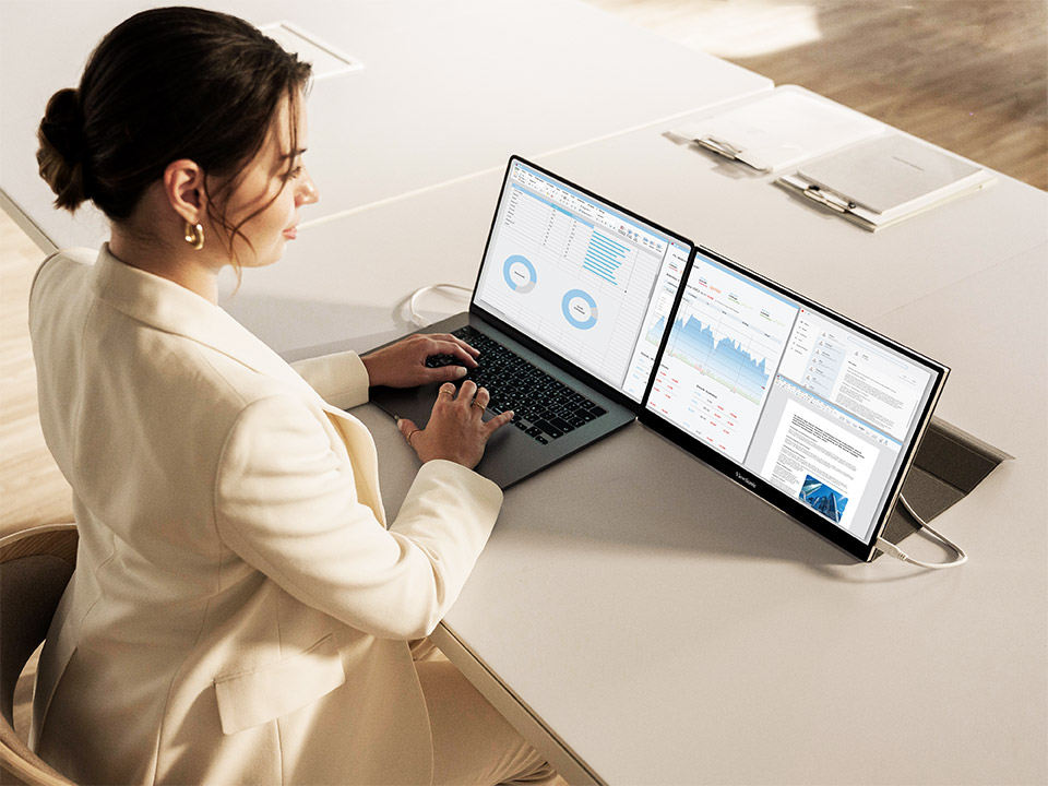 Profesional que utiliza una configuración de doble pantalla para maximizar la productividad de forma remota.