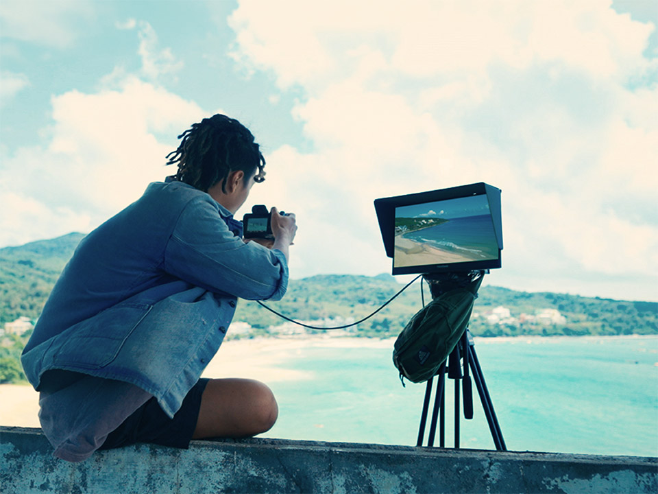 Creator previewing outdoor shots with a portable high-resolution monitor.