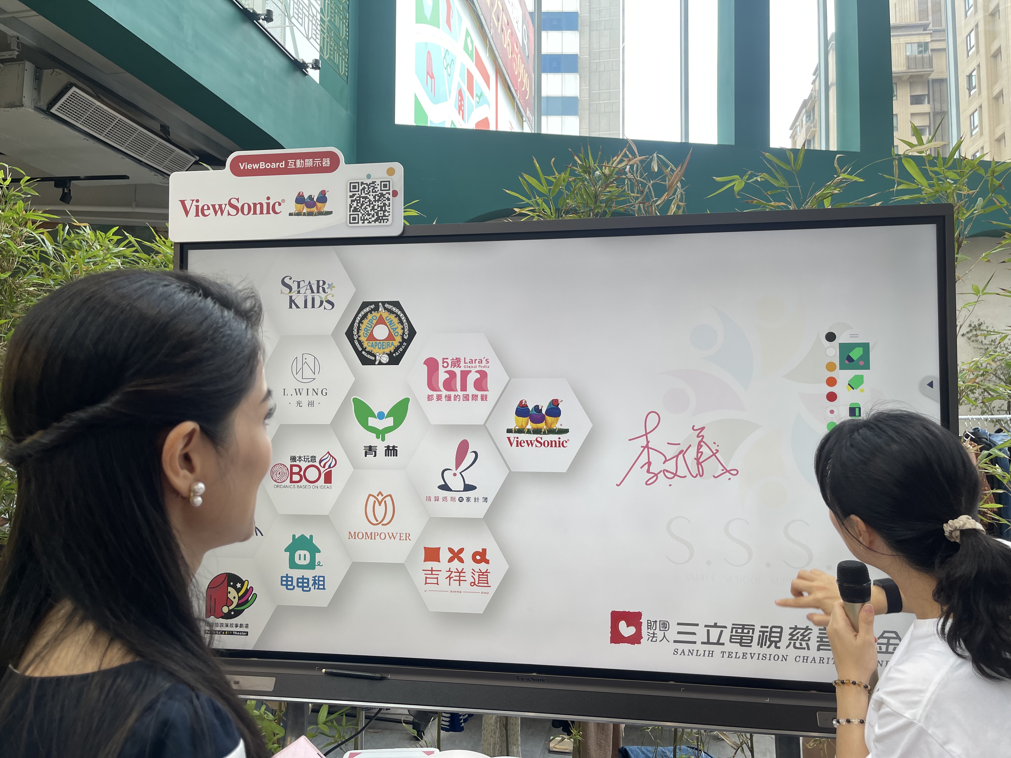 三立新聞主播李文儀和活動創辦人等於 ViewBoard 上簽屬,一起捍衛學童受公平教育權利